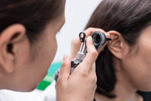 Doctor Performs ear examination on female patient