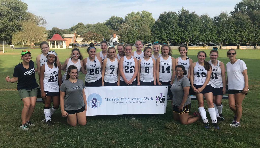The Key School Field Hockey Team Poses with the Marcella Yedid Athletic Week Banner