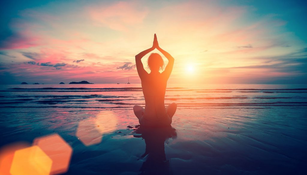 Yoga Prayer Pose overhead on the beach