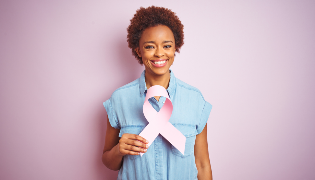 woman holding pink ribbon for breast cancer awareness
