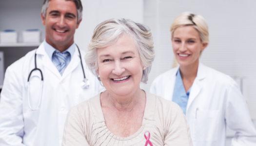 Woman wearing pink breast cancer ribbon with her medical team