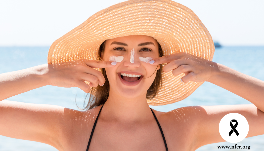 Woman applies sunscreen to face
